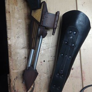 Black disruptor holster.  There is a lace to tie it to the leg, and hooks for a chain baldric.  The house of Martok symbol was added after the custome