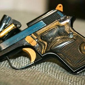 A Beretta 950 Jetfire.  Probably one of the quintessential mouse guns most of these are fairly ugly.  This has custom wood grips and gold work done to