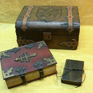 A set of three props, a moldering diary, a battered trunk, and a weighty eldrich tome, commissioned for a short film called The Black Duke. (sold)