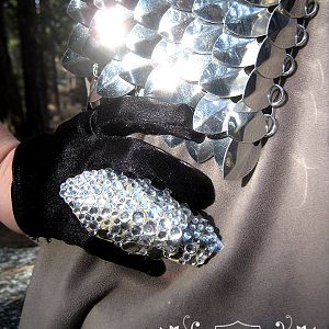 Leather rhinestone encrusted ring and scalemaille vest.