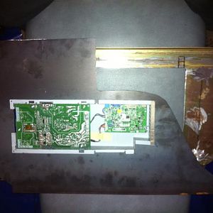 The circuitry box of the monitor fitted within the backpiece. prior to having bent the edges to fit within the surface housing piece.