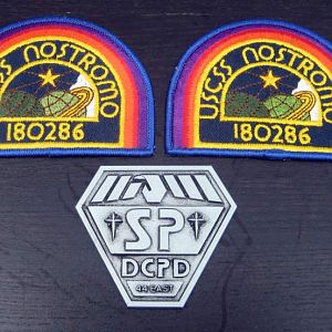 Replica Nostromo badges and original Space Precinct badge